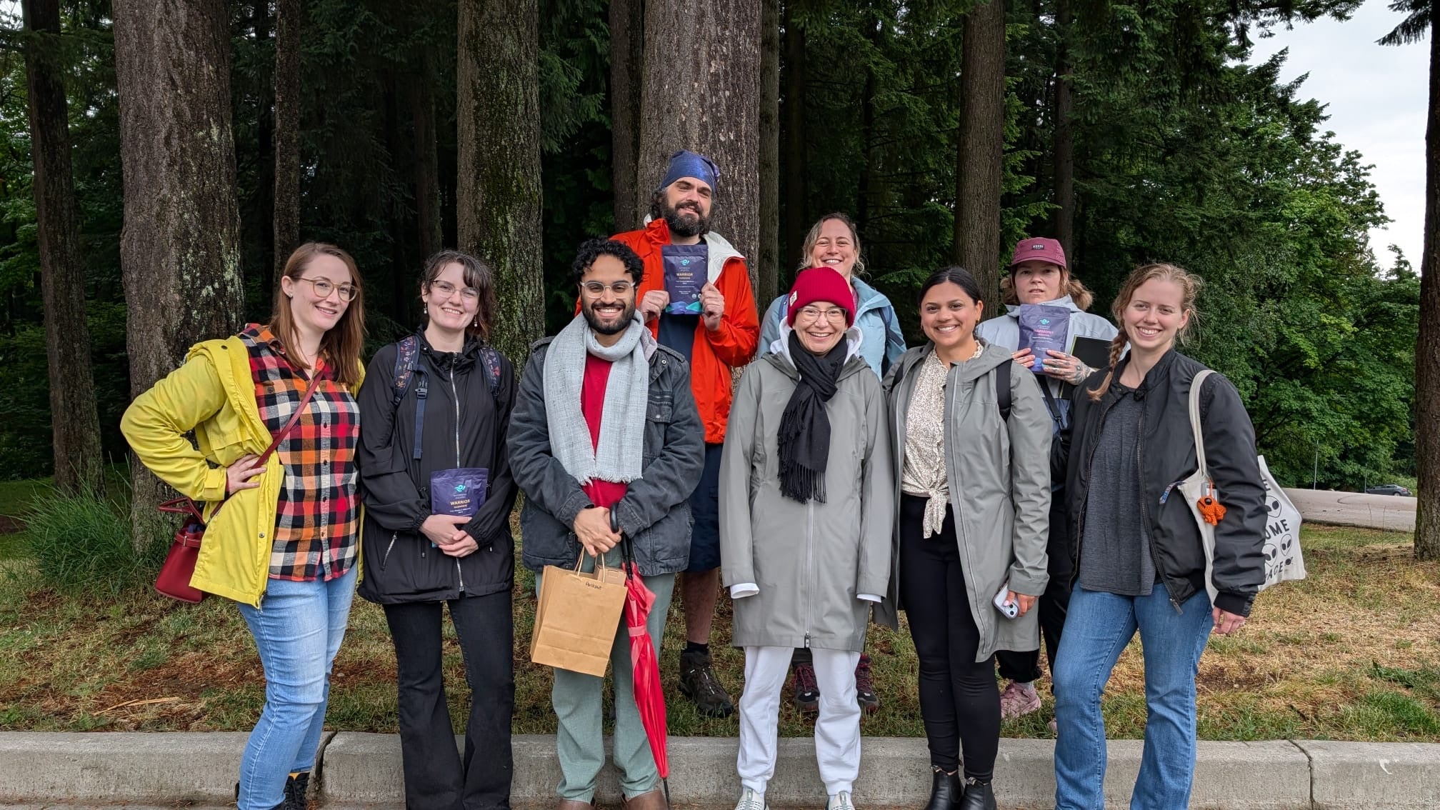 Group of people posing outdoors with trees in the background