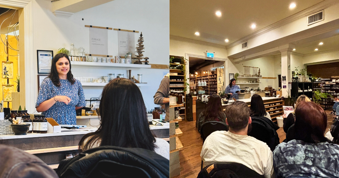 Woman speaking to a group of people in a store setting.